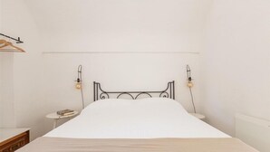 A bed with a metal frame, two bedside tables, and a hanging light fixture. - 2410 Tenuta dei Fragni by Perle di Puglia (Ostuni)
