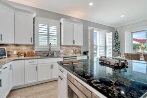 Enjoy cooking in this well-lit kitchen with a large island and dishwasher.