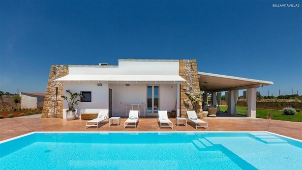 A modern house with a swimming pool, stone walls, and a covered patio with lounge chairs. - 777 Rifinita Villa con Piscina a Presicce (Presicce-Acquarica)