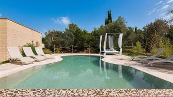 Una piscina con lettini e un ombrellone.