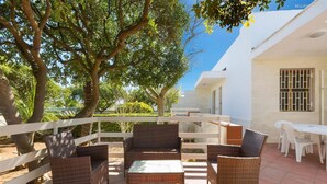 An outdoor patio with wicker furniture and a white fence. - 843 Serra Degli Angeli (Porto Cesareo)