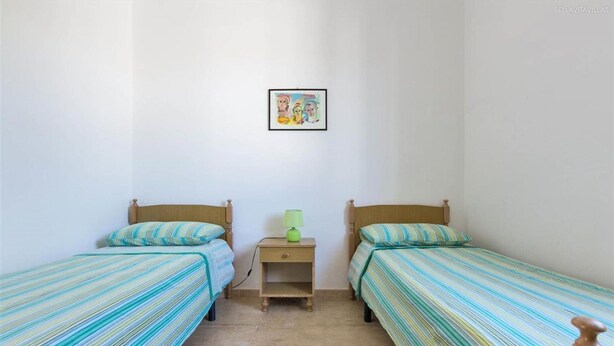 A small, clean room with two single beds, a nightstand with a lamp, and a framed picture on the wall. - 843 Serra Degli Angeli (Porto Cesareo)