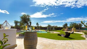 A patio area with a round table, a swimming pool, and outdoor seating. - 1738 Tenuta Degli Ulivi (Melendugno)