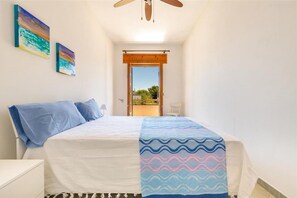 A bedroom with a bed, a ceiling fan, and two paintings on the wall. - 2064 Villa Stella Blu by Barbarhouse (Manduria)