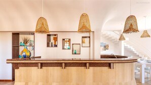 A reception area with a curved wooden counter, multiple hanging wicker lamps, and a staircase in the background. - 2064 Villa Stella Blu by Barbarhouse (Manduria)