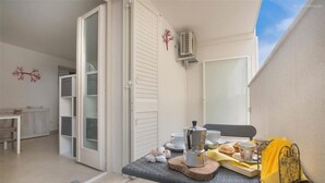 A balcony with a table set for breakfast, including a coffee pot, cups, and pastries. - 2199 Al Castello Home Holidays - Mono by Barbarhouse (Otranto)