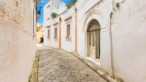 A narrow cobblestone street flanked by white buildings with arched doorways and windows. - 574 Loft nel Centro Storico di Presicce (Presicce-Acquarica)