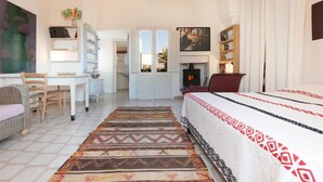 A spacious room with a bed, a desk, a chair, a bookshelf, and a fireplace. - 574 Loft nel Centro Storico di Presicce (Presicce-Acquarica)