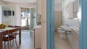 Una cucina moderna con zona pranzo, un bagno con doccia e vista esterna.