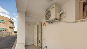 A balcony with a table, chairs, and an air conditioning unit. - 2200 Al Castello Home Holidays - Bilo by Barbarhouse (Otranto)