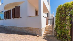 A white building with a stone base, a staircase, and a small garden area. - 2406 Villa Cieloazzurro - Mono B by Barbarhouse (Nardò)