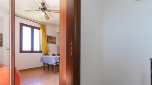 A room with a dining area, a ceiling fan, and a window with yellow curtains. - 2406 Villa Cieloazzurro - Mono B by Barbarhouse (Nardò)