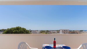 A balcony with a table set for two, overlooking a coastal town. - 2406 Villa Cieloazzurro - Mono B by Barbarhouse (Nardò)
