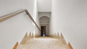 A staircase with a handrail leading to a door at the top. - 1132 Attico Isola dei Conigli (Porto Cesareo)