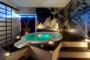 A spa area with a hot tub, decorative stones, and a mural on the wall. - 1745 Silver Hotel - Matrimoniale (Matino)