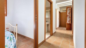 Egy folyosó, a bal oldalon egy ággyal, egy nyitott ajtón keresztül belátható fürdőszobával, és egy zuhanyzóval, melyet függönnyel választhattak el.