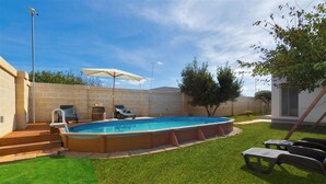 Ein Garten mit Pool, Whirlpool und Gartenmöbeln.