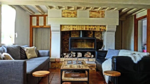 Ein gemütliches Wohnzimmer mit Kamin, zwei Sofas, einem Couchtisch und Holzboden.