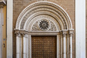 A detailed architectural entrance with a decorative arch, a central circular window, and a grid-patterned door. - Walking distance for tourism, shopping and business. Do as Romans do (Rome)