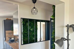 A modern kitchen with a wooden countertop, a built-in sink, and a black hanging light fixture. - Apartment - Concarneau - Chez Antoine (Concarneau)