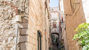 A narrow stone alleyway with a staircase leading to a building entrance. - Apartment Neve - Two Bedroom Apartment (Dubrovnik)