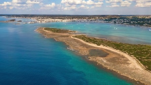 An aerial view of a coastal area with clear blue waters, sandy beaches, and a small town in the background. - 1283 B B Dreams and Delights - Sea Sight Camera Familiare (Porto Cesareo)