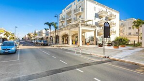 A multi-story hotel with balconies, a central courtyard, and a clear blue sky. - 2122 Appartamento Corso Italia II by Barbarhouse (Gallipoli)