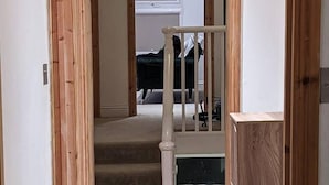 Eine Treppe führt zu einem Zimmer mit einem Bett und einem Fenster.