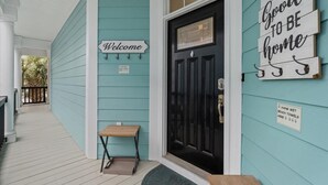 A turquoise house exterior with a black door, a welcome sign, and a sign that says "It's so good to be home." - Surfside Beach Family Retreat w/ Private Pool & 5BRs (Surfside Beach)