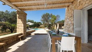 An outdoor dining area with a pool and stone walls. - 496 La Serrazza in Pescoluse Posto Vecchio (Salve)