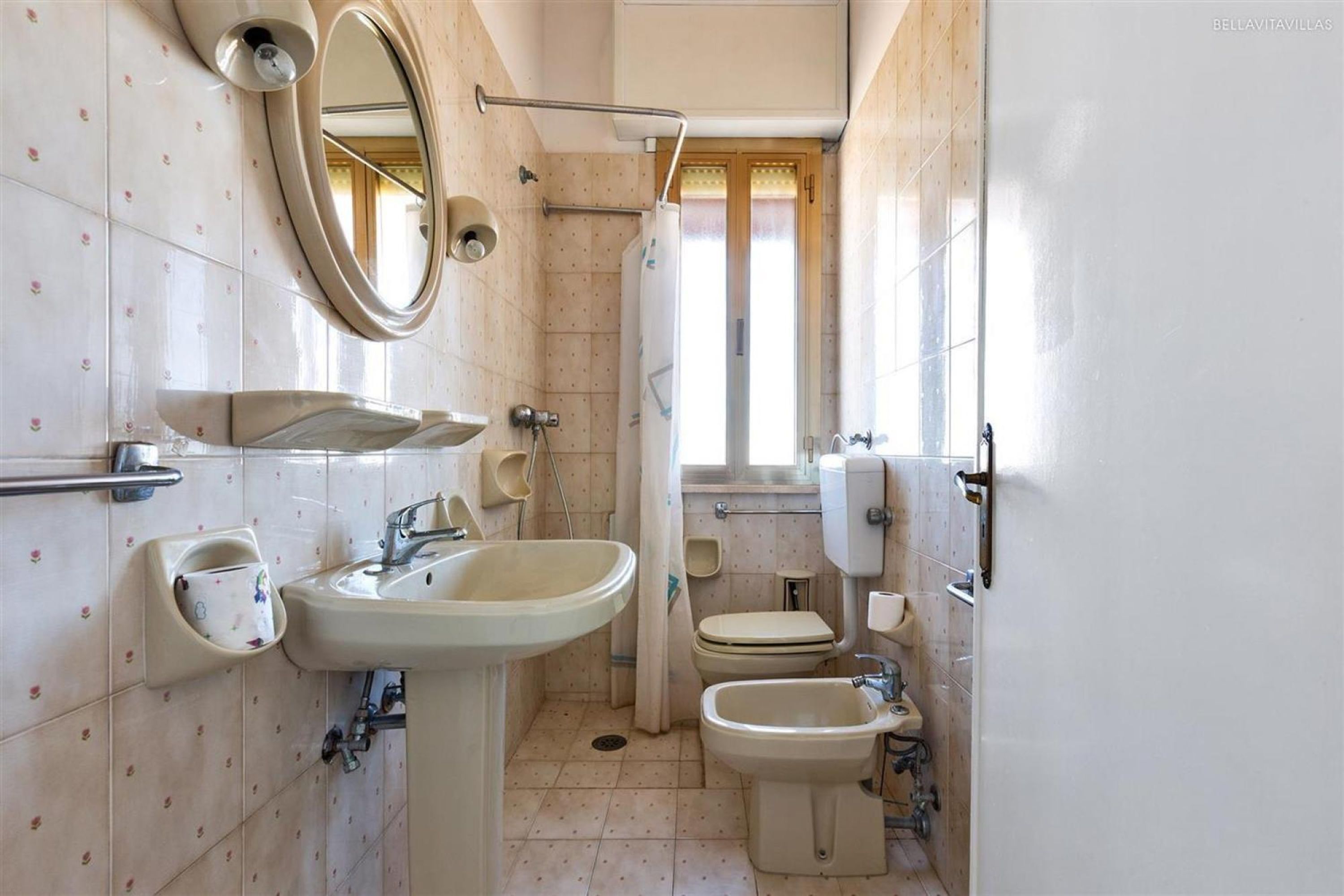 A compact bathroom with a sink, bidet, and toilet.