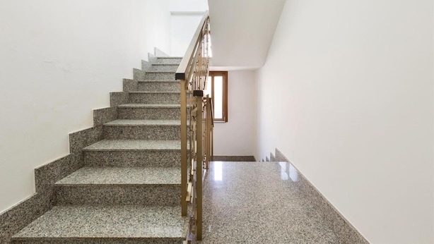 A staircase with granite steps and a metal handrail, leading to a room with a window. - 1298 Versomare - Monolocale Lu Ientu (Porto Cesareo)