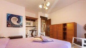 Ein Schlafzimmer mit einem Bett, einem Holzschrank und einem Bild an der Wand.