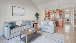 Un salon moderne avec un canapé, une table basse et un tableau accroché au mur.