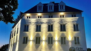 Un hotel de varios pisos con ventanas iluminadas y un cartel que indica que es el "Orée des Plages".