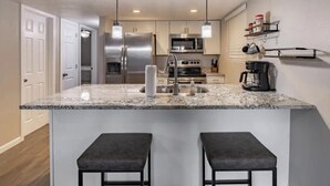 A modern kitchen with a granite countertop, stainless steel appliances, and pendant lighting. - Amazing Views - Peaceful surroundings - Pets OK with fee (Ruidoso)