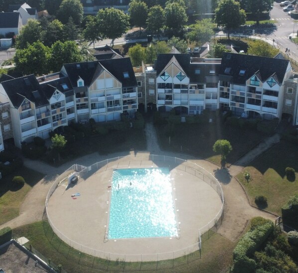 A multi-story building with a central courtyard featuring a swimming pool.