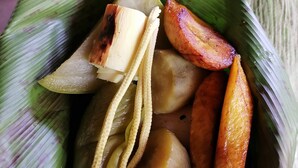 A plate of food with various items including a banana, corn, and roasted vegetables. - Bribri Ù sule (Bratsi)