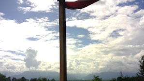 A view of a mountainous landscape with a flagpole in the foreground. - Bribri Ù sule (Bratsi)