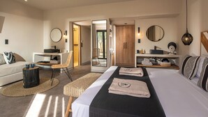 A modern hotel room with a large bed, a sitting area with a sofa and chair, a small desk, and a wardrobe. - Indigo Inn Casa - Adults Only (Hersonissos)