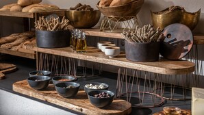 A bakery display with various breads and pastries, along with bowls of ingredients and spices. - Indigo Inn Casa - Adults Only (Hersonissos)