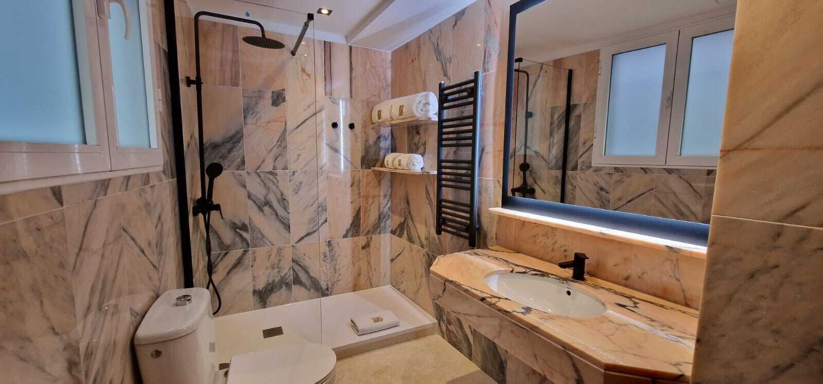 Un baño moderno con ducha, inodoro y lavamanos.