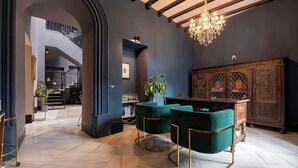 A modern interior with a staircase, a chandelier, and a wooden cabinet. - Boutique Suites (Arcos de la Frontera)