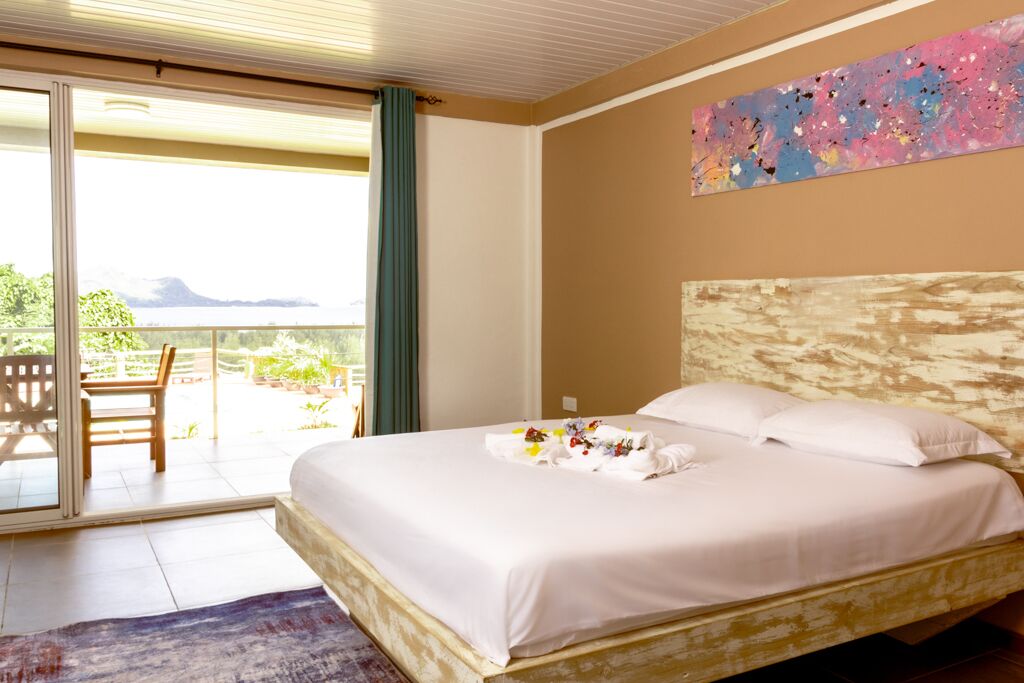 Una habitación de hotel con una cama, un ventanal y vistas al exterior.