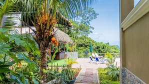 A tropical resort with a pool area, palm trees, and lounge chairs. - The Habitat Sesel (Mahé Island)