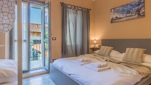 Una habitación de hotel con una cama, vistas al exterior y un cuadro en la pared.