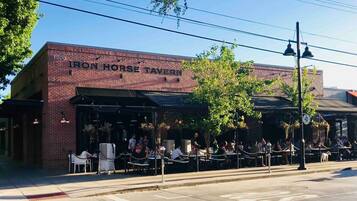 An exterior of the Iron Horse Tavern with outdoor seating and a brick facade.