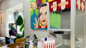 Et køkken med en popcornmaskine, en skål og to flasker på en bordplade.