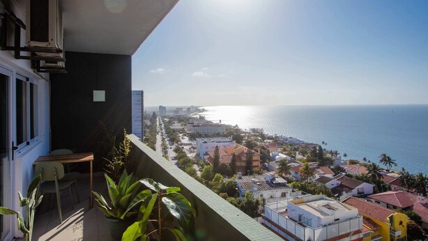 Uma varanda com vista para o mar e edifícios.