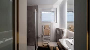 Habitación doble | Baño | Ducha, secador de pelo, toallas y jabón